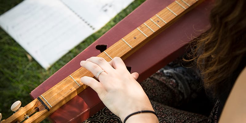 Close up aerial view of a student playing a dulcimer