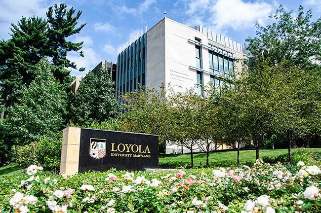Exterior of Donnelly Science Center with a Loyola University Maryland sign in front surrounded by flowers